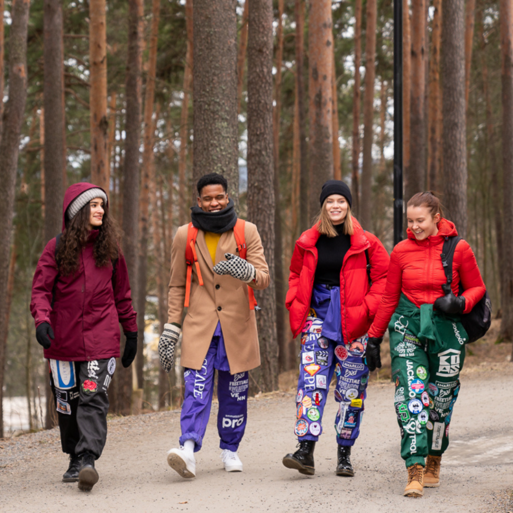 Opiskelijoita kävelemässä metsätiellä.