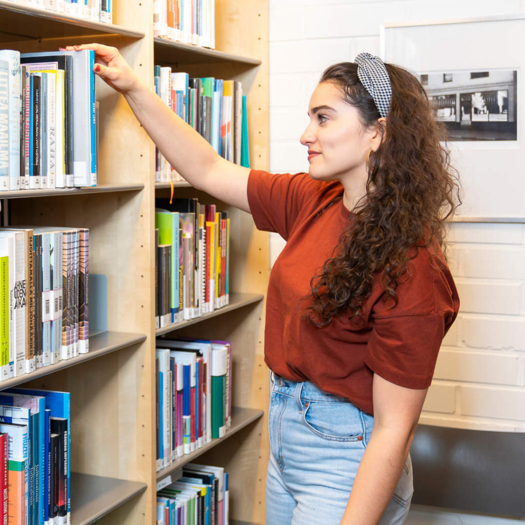 Student girl in front of a bookshelf.