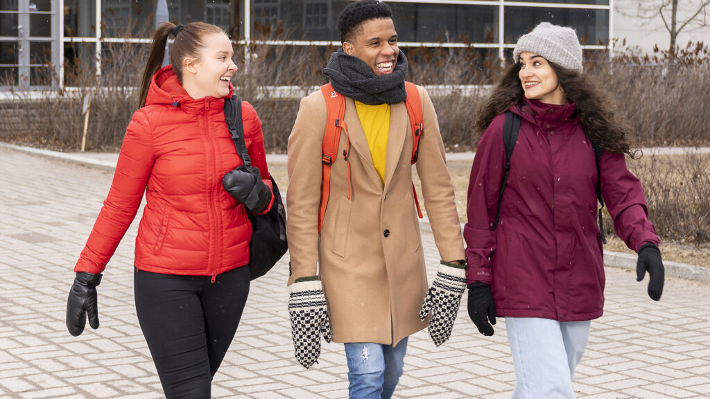 Tre studenter på campus.