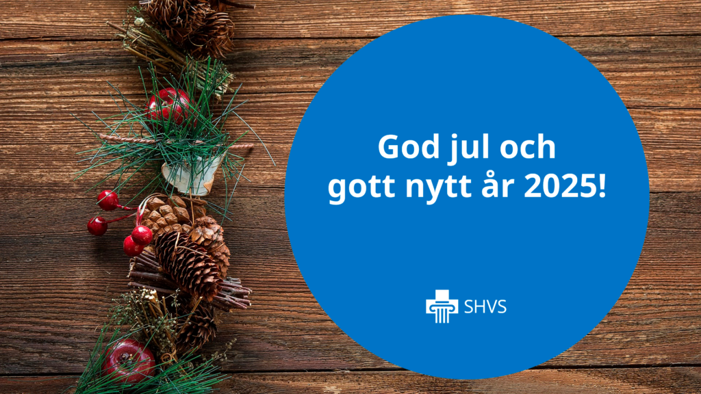 Juldekorationer på brun träbakgrund, SHVS-loggan och texten "God jul och gott nytt år 2025".